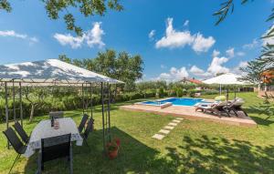 a backyard with a pool and a table and chairs at Villa Antonela in Radetići