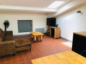 Habitación con sofá, mesa y TV. en DOLCE VITA en Carcassonne