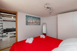 a bedroom with a red bed with towels on it at Old Town Charming Nest in Dubrovnik