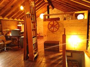 een zolderkamer met een bureau en een tafel in een gebouw bij Cabaña en las montañas in San Roque de Ríomiera