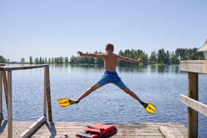 Un jeune homme saute d'un quai dans l'eau dans l'établissement Herttua Hotel and Spa, à Kerimäki