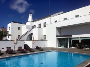 a swimming pool in front of a white building at Azores Youth Hostels - Santa Maria in Vila do Porto