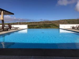 a large swimming pool with a view of a mountain at Azores Youth Hostels - Santa Maria in Vila do Porto