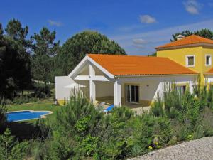 een geel en wit huis met een zwembad bij Quinta do Peru I in Quinta do Conde