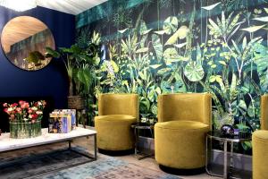 a room with three chairs and a wall with plants at 1 Craven Hill Gardens in London