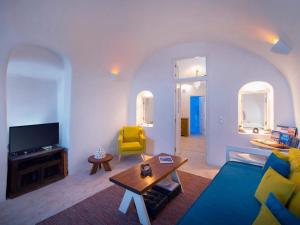 a living room with a blue couch and a yellow chair at Anemi House & Villas in Oia