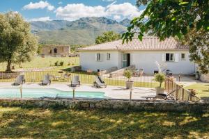 a villa with a swimming pool and a house at B&B A Chjusellina in Corte