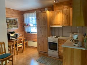 a kitchen with wooden cabinets and a table and a stove at Norefri apartment with sauna and Wi-Fi at Nedre Norefjell in Noresund