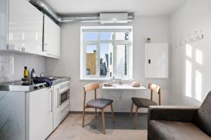 a kitchen with a table and chairs in a room at Aalesund City Apartment in Ålesund
