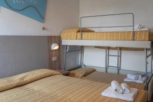 two beds in a room with two bunk beds at Hotel Astrid in Cervia