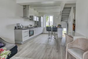 a kitchen and living room with white walls and wooden floors at Kerelen in Carantec +7 photos