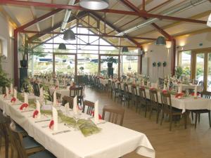 een feestzaal met witte tafels en stoelen bij Gasthaus Herrig in Meckel