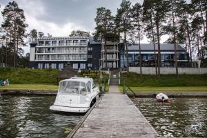 un bateau amarré à un quai en face d'un bâtiment dans l'établissement Pokoje - MARINA BORKI, à Augustów