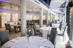 a dining room with white tables and chairs at Pokoje - MARINA BORKI in Augustów