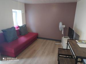sala de estar con sofá rojo y mesa en Chambre tranquille et confortable pour étape en Ancy-le-Libre