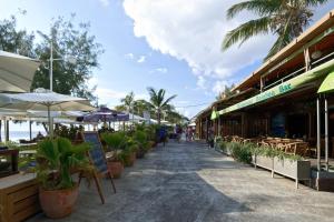 una strada in un resort con piante e ombrelloni di Appartement Croisière bleue à 20 m de la plage de Boucan canot pour 4 personnes a Boucan Canot