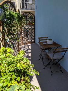 una mesa y sillas en un patio con plantas en Gaia14, en Salerno