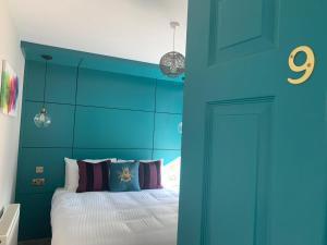 a blue bedroom with a bed and a blue wall at Lynwood House in Southport