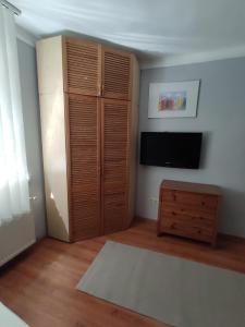- un salon avec une télévision et une armoire en bois dans l'établissement Star apartman, à Balatonalmádi