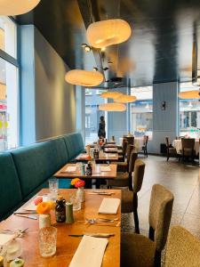 uma sala de jantar com mesas longas e cadeiras em B&B Belle de Nuit em Ostend
