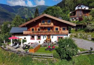 a large wooden house with a balcony on a hill at Chalet Der Bichlhof in Zell am See