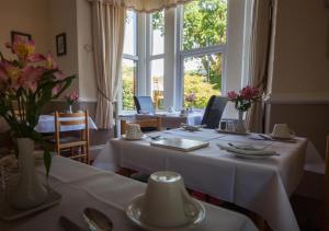 a dining room with a table with a white table cloth at Mary's Court Guest House - Mairlys in Betws-y-coed