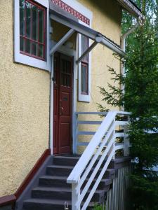 ein Haus mit einer Treppe, die zu einer roten Tür führt in der Unterkunft Wivi`s in Jyväskylä