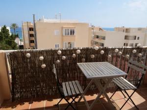 a table and chairs on a balcony with a fence at Bonito apartamento a 20m del mar in Es Pujols +1 photo