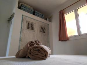 a towel sitting on a bed in front of a door at Bonito apartamento a 20m del mar in Es Pujols