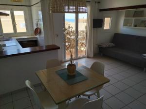 ein Wohnzimmer mit einem Tisch, Stühlen und einem Sofa in der Unterkunft Bonito apartamento a 20m del mar in Es Pujols