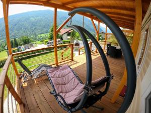 a rocking chair on a deck with a view at MOBILE HOUSE KD in Tolmin