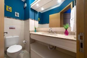 a bathroom with a toilet and a sink with a mirror at GRAMADO SOLAR REAL - 2 APTS de 2 quartos no mesmo prédio, cada um comporta até 7 pessoas - IDEAL PARA GRUPOS - central - IDEAL PARA ANDAR A PÉ, nesta plataforma desde janeiro de 2016, oferecemos CREDIBILIDADE - seu PET é bem-vindo - GARAGEM COBERTA in Gramado +81 photos