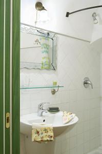 a white bathroom with a sink and a mirror at La Casa dei Nonni Castelbianco in Castelbianco