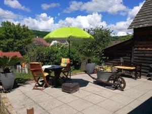 un patio con una mesa y una sombrilla verde en Ferienwohnung Graf en Tübingen