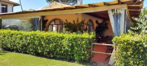 a house with an awning next to a hedge at Airone Pisa Hotel Ristorante in Pisa