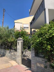 ogrodzenie z bramą przed budynkiem w obiekcie Glykanisos Suites w mieście Néa Péramos