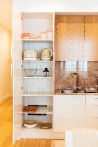 a kitchen with white cabinets and a sink at Apartamentos Ferreiros by Heart of Funchal in Funchal +125 photos