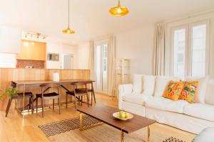 a living room with a white couch and a table at Apartamentos Ferreiros by Heart of Funchal in Funchal