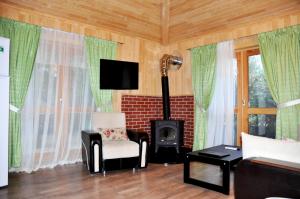 a living room with a fireplace and green curtains at Arcadia Villas in Cıralı