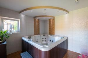 a large bath tub in a bathroom with a mirror at Pensjonat Bursztyn in Dąbki +17 photos