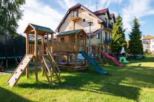 a house with a playground in the yard at Pensjonat Bursztyn in Dąbki