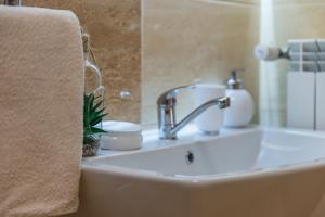 a bathroom sink with a faucet and a towel at Perła Wadowic Trybunalska in Wadowice