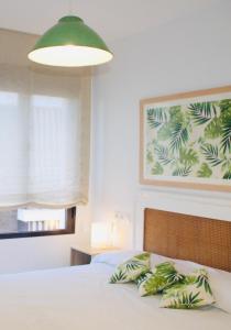 1 dormitorio con 1 cama con almohadas verdes y blancas en Nuevo apartamento en pleno centro, en Córdoba