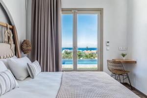 sypialnia z łóżkiem i widokiem na ocean w obiekcie Villa Kingstone w mieście Skopelos