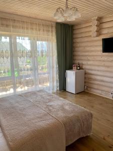 1 dormitorio con cama y ventana grande en Смерекова хата en Zatoka