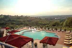 a view of a swimming pool with umbrellas at Villa Tolomei Hotel & Resort in Florence