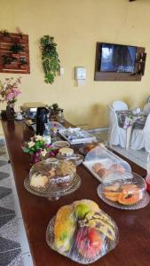 a table with several plates of food on it at Pousada e Posto Amigão in São Gonçalo do Amarante