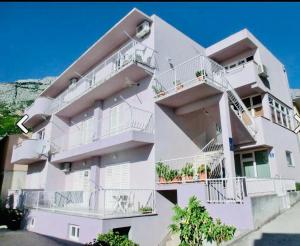 a white apartment building with balconies on it at Apartman Lala in Baška Voda