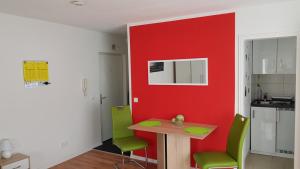 a kitchen with a red wall and a table and chairs at Apartment Gablenberg in Stuttgart +3 photos