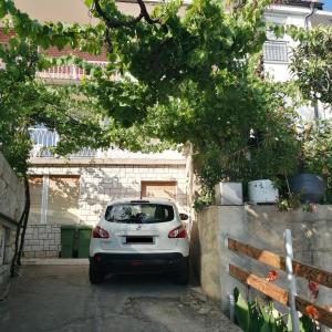 une voiture blanche garée sur un parking dans l'établissement Apartmani Marijan, à Crikvenica